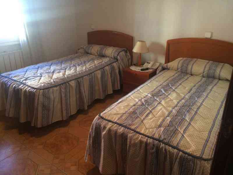 Dos somieres, dos colchones, una mesilla de noche