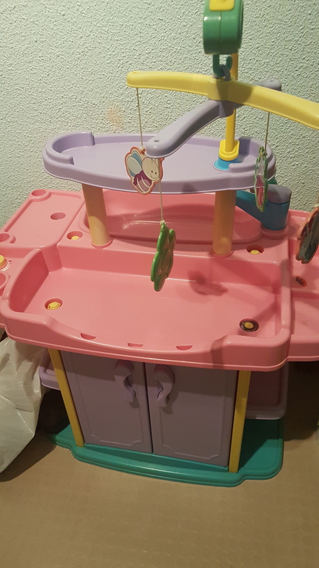 Cambiador con armario, trona y bañera de juguete.