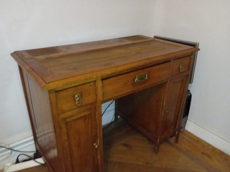 Escritorio antiguo con cajones y puertas laterales, algo desvencijado pero utilizable