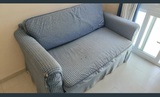 Sofá cama de tela a cuadros en tonos azules y blancos.